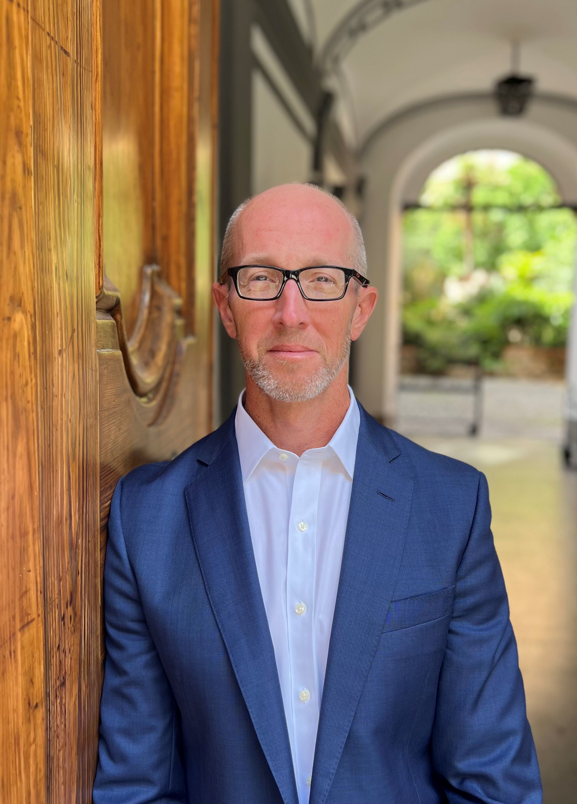 Headshot of Dr. Mike Winters in front of arched building with exterior patio